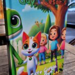 Angled photo of Guy & Cesar’s Safe Circle hardcover book standing on a wooden table outdoors.